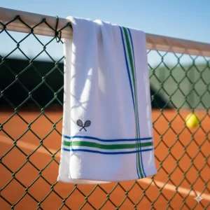A quick-dry tennis towel hanging on a fence by its loop, airing out rapidly after use.