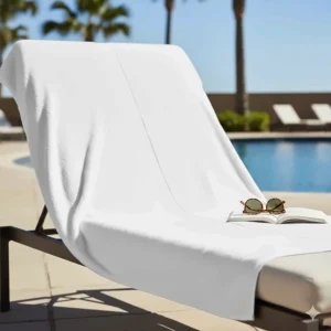 An extra large bath towel 35x70 spread across a pool lounge chair for maximum coverage.