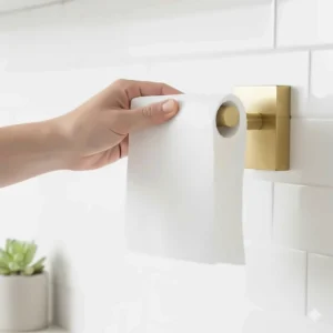 Action shot demonstrating the one-handed tear mechanism of the heavy-duty brass paper towel holder.