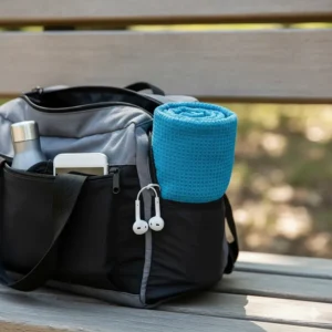 An illustration of a rolled-up quick drying bath towel tucked into a compact gym bag, highlighting its portability.