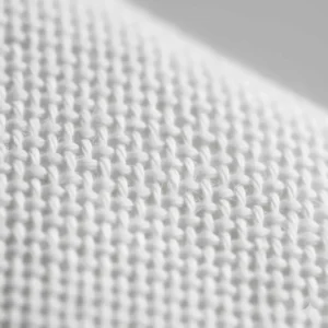 A detailed close-up illustration of a tight weave pattern that prevents lint and shedding in luxury bath towels.