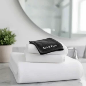 Small black embroidered makeup removal towels to prevent staining on white Airbnb bath towels.